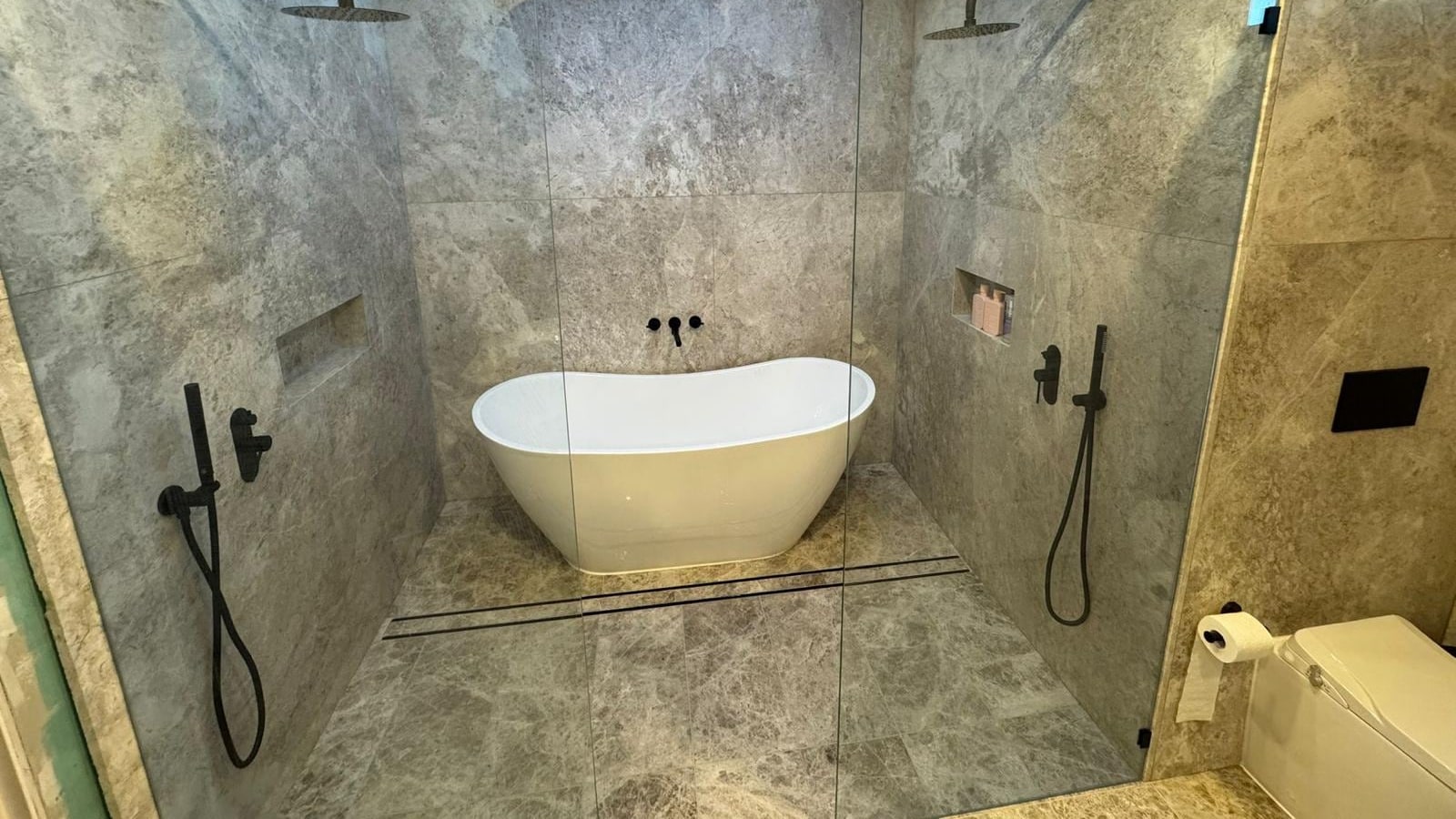 Renovated ensuite with freestanding bath between twin showers