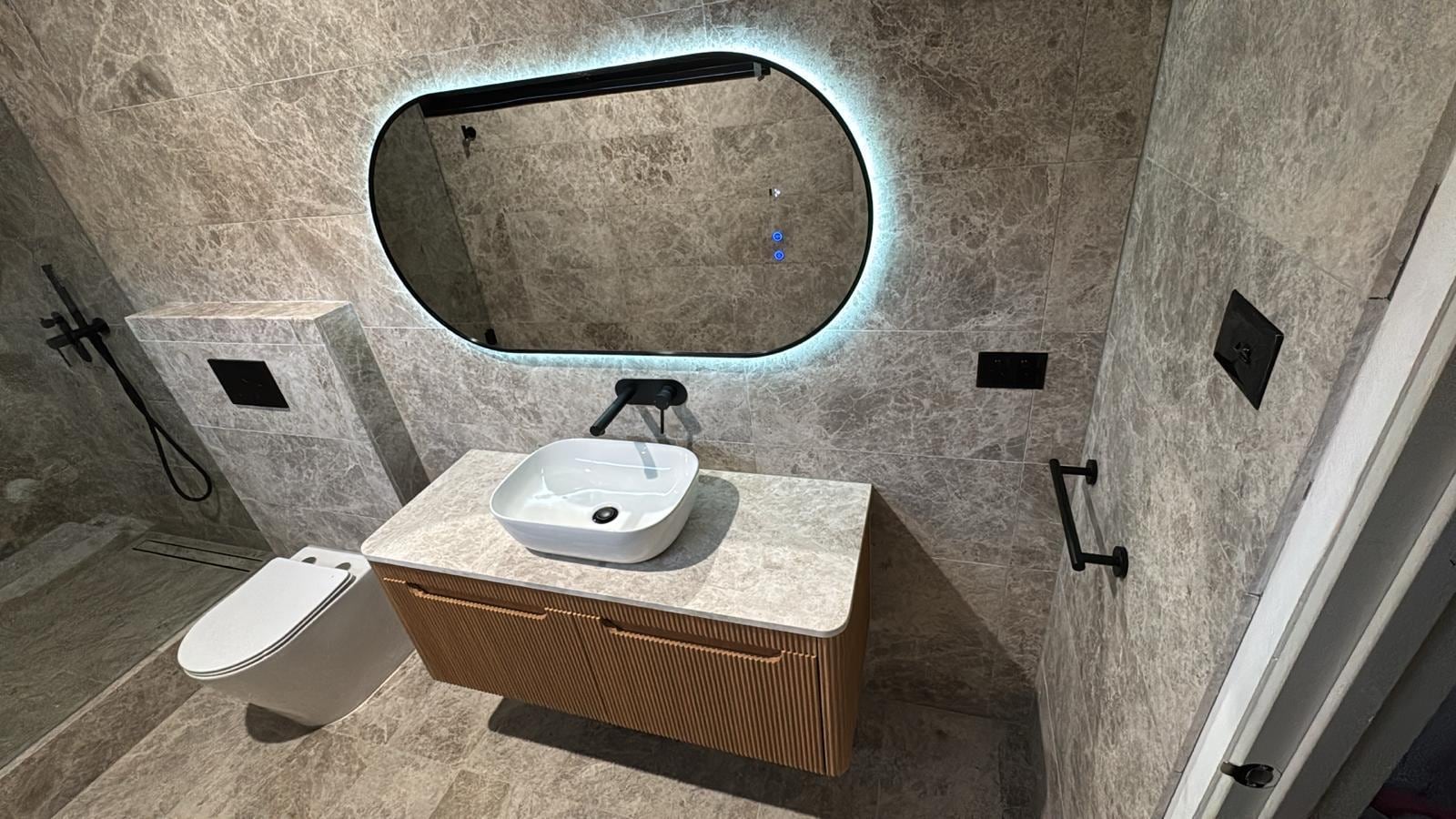 Renovated Melbourne bathroom vanity with fluted timber and backlit mirror