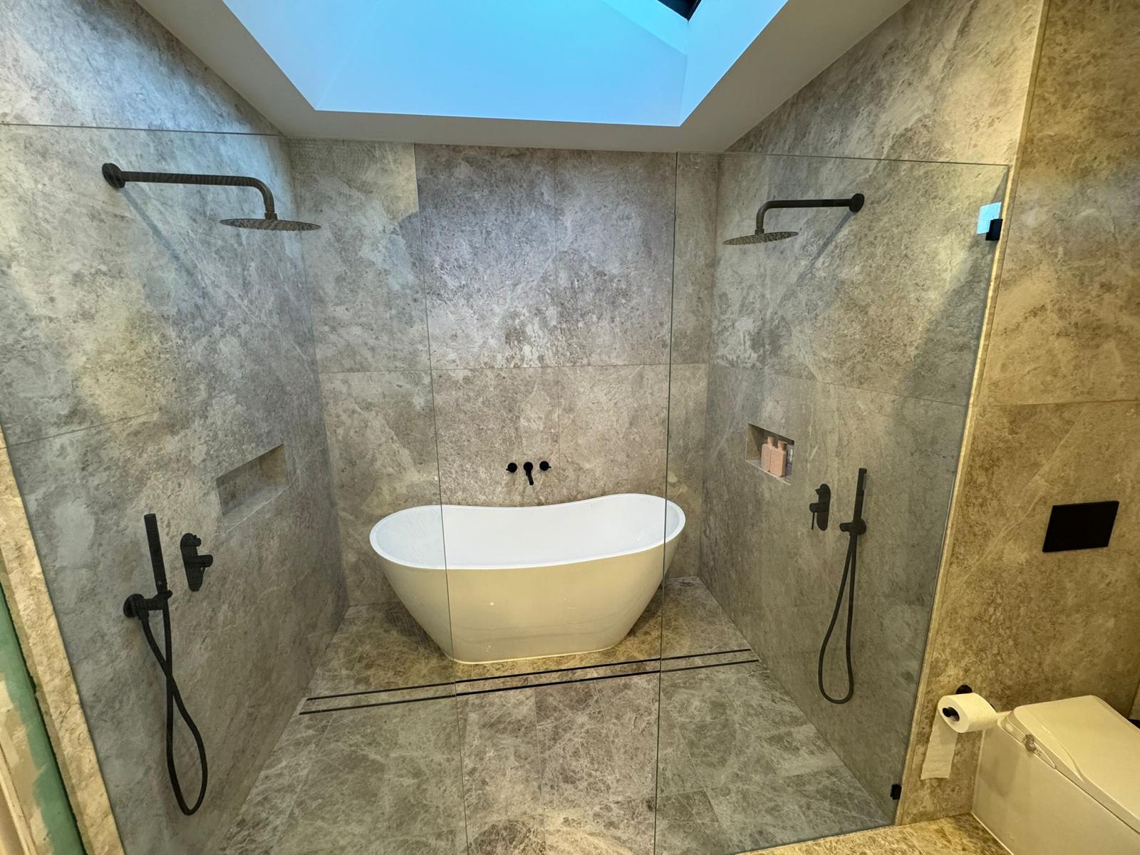 Stone Ensuite, Brighton - freestanding bath between twin rain showers