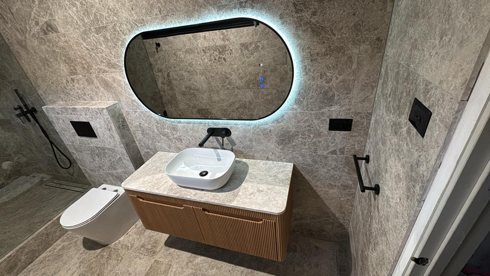 Backlit mirror and fluted timber vanity