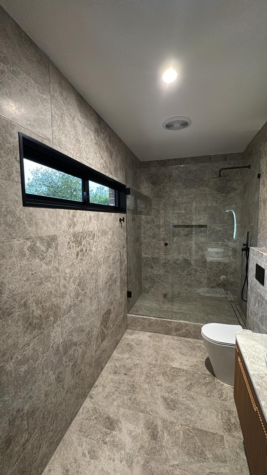 Walk-in shower with black tapware