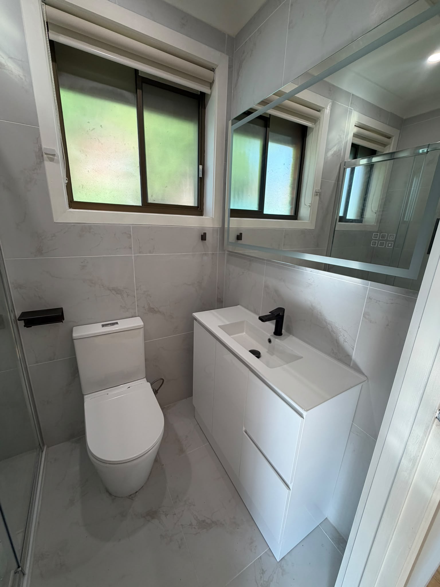 Built In project - Compact bathroom with white vanity and LED mirror