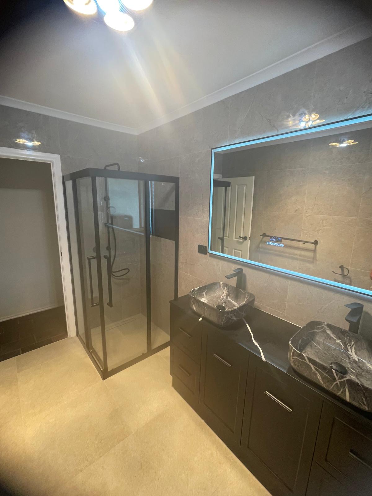 Dark ensuite with twin marble basins